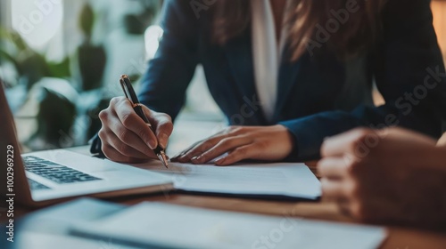 Wallpaper Mural A person signing documents at a desk with a laptop, emphasizing business collaboration. Torontodigital.ca