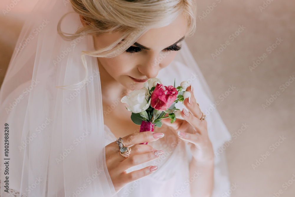 Naklejka premium A bride is lying on a bed with her hands on her face. She is wearing a white gown and a veil