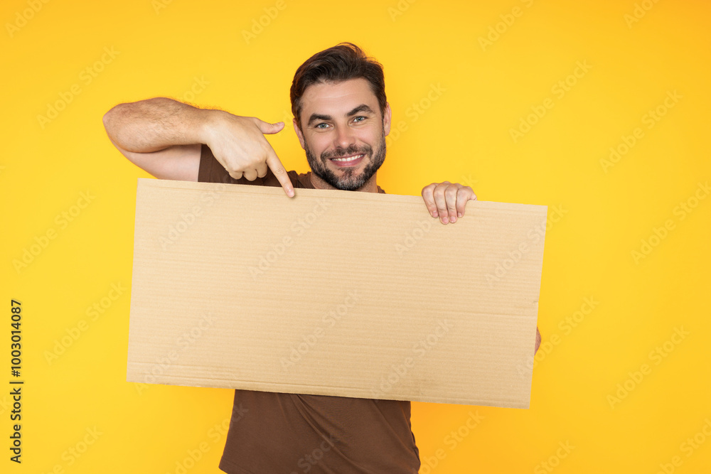 Man holds sign, blank card. Placard ready for your product. Man showing blank sign board over studio isolated background, pointing finger. Empty blank board. Area for advertising, copy space. Man holds sign, blank card. Placard ready for your product. Man showing blank sign board over studio isolated background, pointing finger. Empty blank board. Area for advertising, copy space.