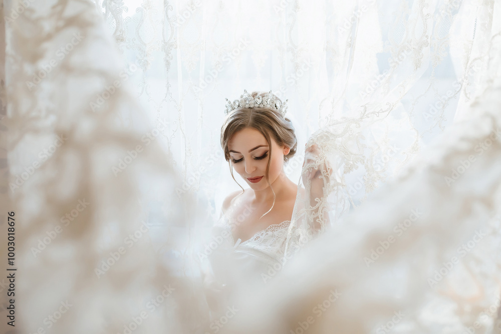 A woman in a white dress is standing in front of a curtain. She is wearing a tiara and has her hair in a bun A woman in a white dress is standing in front of a curtain. She is wearing a tiara and has her hair in a bun