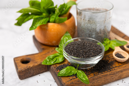 Basil seeds on textured wooden background. Close-up. Superfood. Ocimum basilicum. Organic basil seeds. selasih. Space for text. Copy space. photo