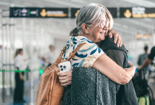 Couple of women hugging and goodbye in airport area for arriving or departing trip, feeling for long distance relationship. Two mature women embracing each other affectionately before leaving