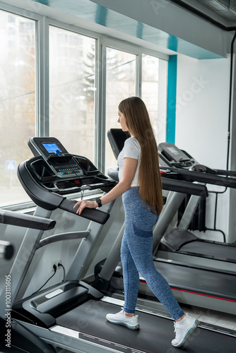  athletic sportswoman woman doin exercise with treadmill at gym photo