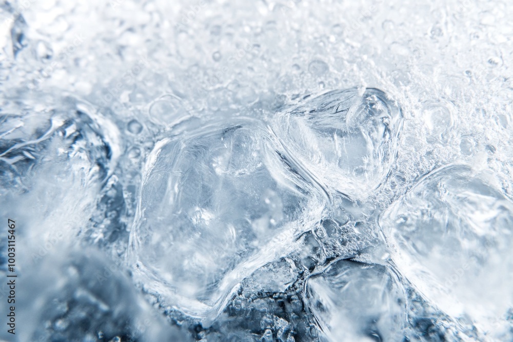 Close up of ice cubes melting in clear water with bubbles and reflections in bright light Close up of ice cubes melting in clear water with bubbles and reflections in bright light