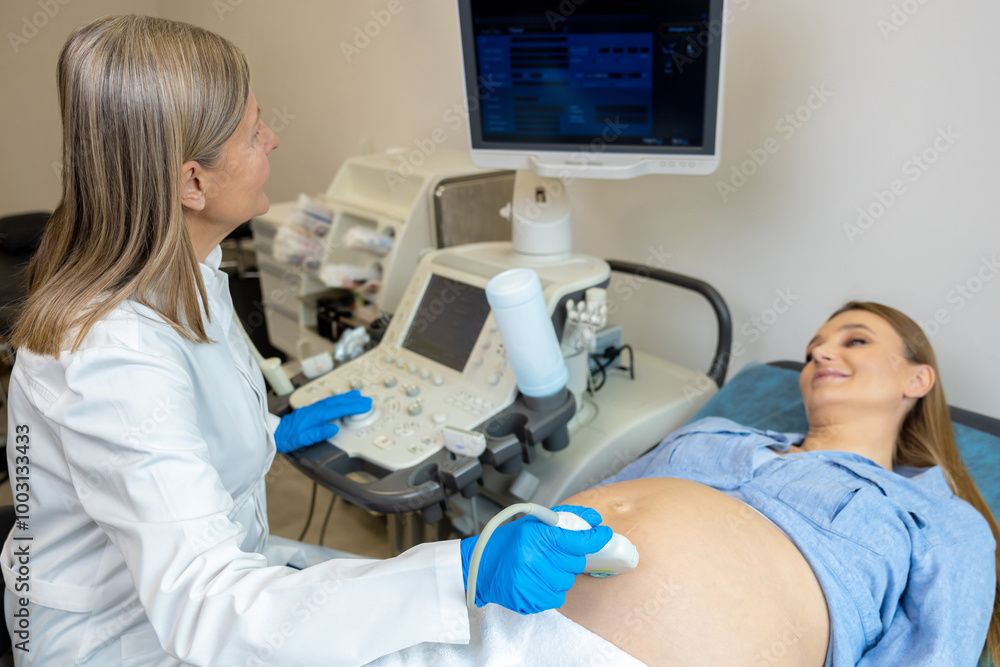 Long-haired mature doctor doing ultrasonography to a pregnant woman Long-haired mature doctor doing ultrasonography to a pregnant woman