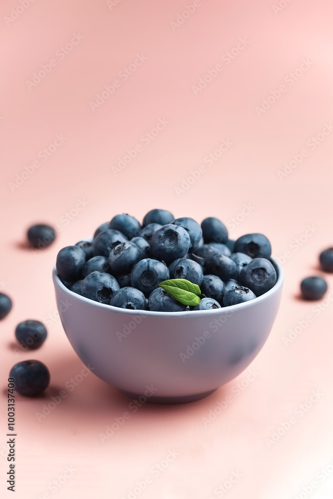Blueberries in bowl with its fruit scattered isolated on pastel background Blueberries in bowl with its fruit scattered isolated on pastel background