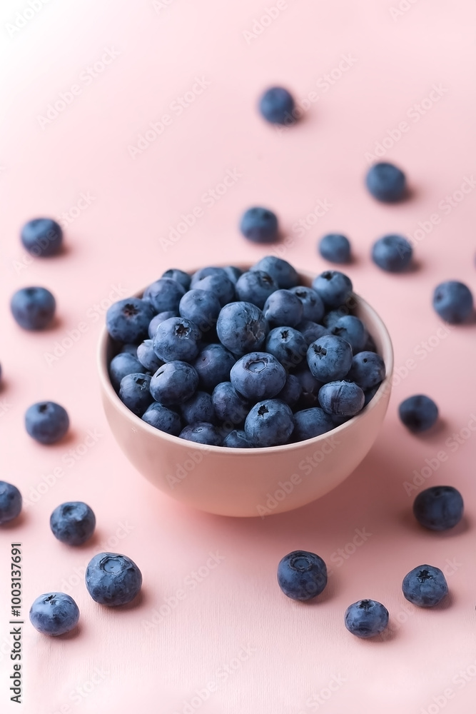 Blueberries in bowl with its fruit scattered isolated on pastel background Blueberries in bowl with its fruit scattered isolated on pastel background