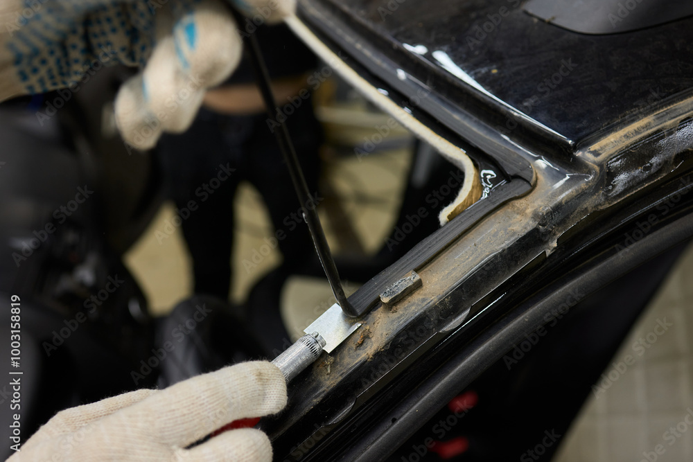 Obraz premium Automobile special workers remove old windscreen or windshield of a car in auto service station garage. Background