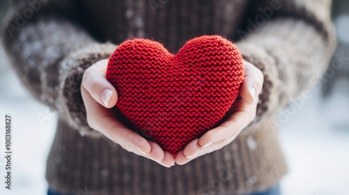 Hands cradling a knitted red heart against a snowy background a symbol of love and friendship