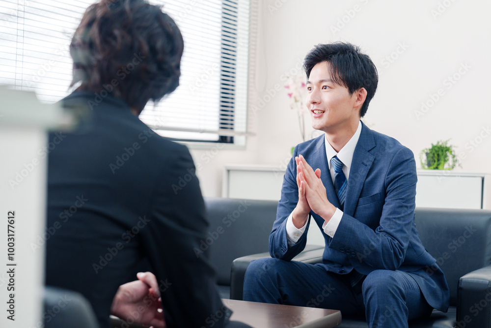 得意先と商談をするスーツを着たビジネスマン