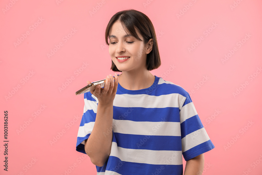 Beautiful woman recording voice message via smartphone on pink background Beautiful woman recording voice message via smartphone on pink background
