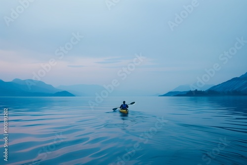 A man in a yellow kayak is paddling on a lake