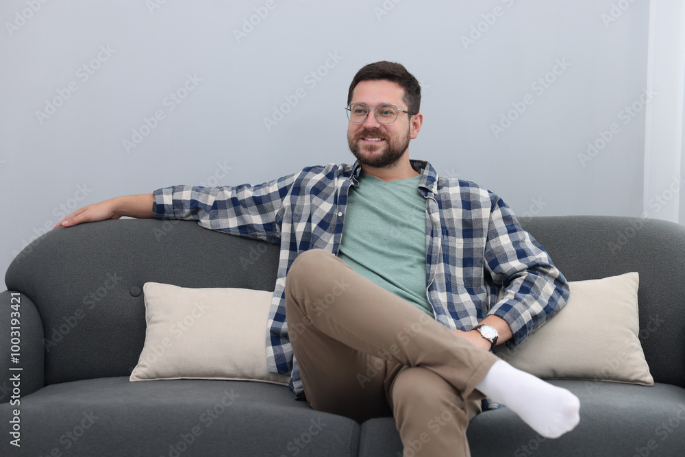 Smiling man relaxing on sofa at home Smiling man relaxing on sofa at home