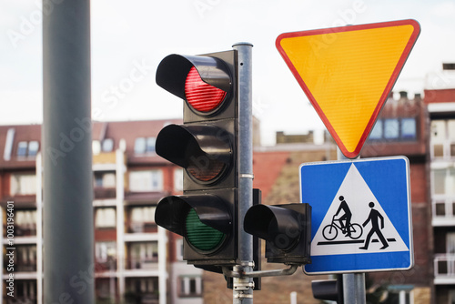 Red traffic light signal. Give way traffic sign. Smart traffic light. City crossing with semaphore. Pedestrian crossing road sign. Bad weatherd road conditions. Block of flats neighbourhood. photo