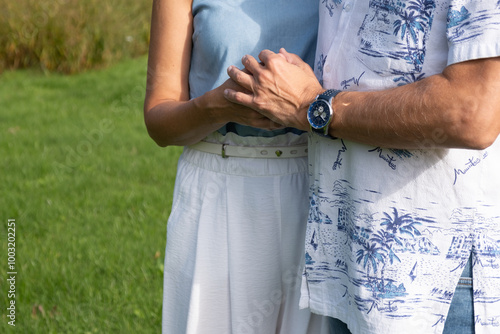 Couple showing affection, middle-aged hands, symbol of love and closeness, outdoors, loving embrace concept