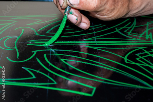 the artist draws a pinstriping styled drawing with a special brush