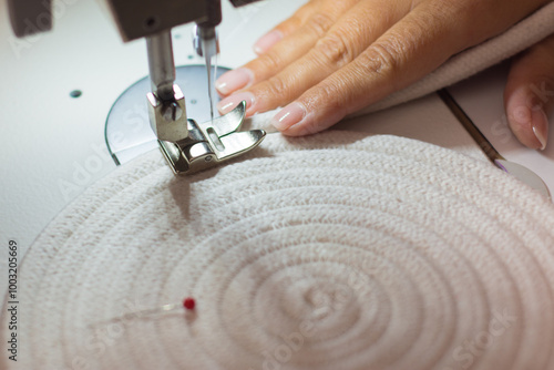 Close-up of a woman's hands sewing on a sewing machine with moving needle. handmade rope crafts