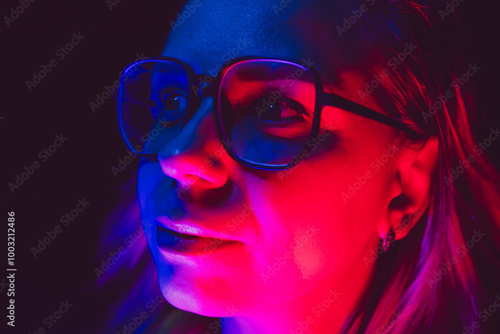 A woman with glasses illuminated by colorful lights on a dark night, creating a striking visual effect and mood A woman with glasses illuminated by colorful lights on a dark night, creating a striking visual effect and mood