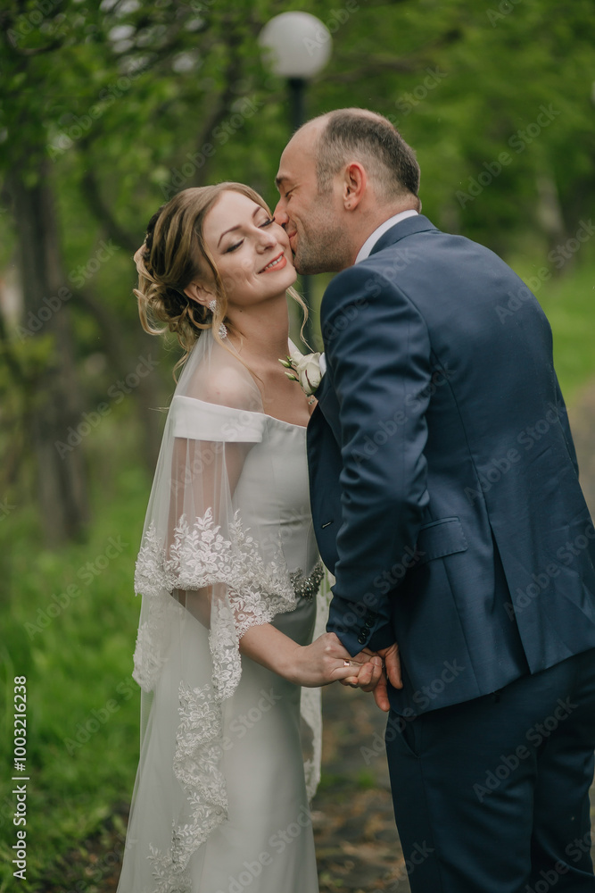 A man and a woman are kissing each other. The man is wearing a blue suit and the woman is wearing a white dress A man and a woman are kissing each other. The man is wearing a blue suit and the woman is wearing a white dress