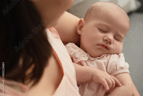 Happy mother with cute little baby sitting in living room