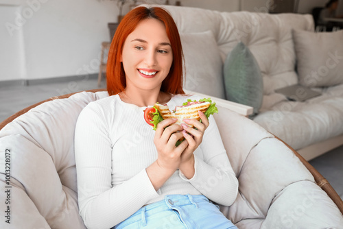 Young redhead woman eating ...