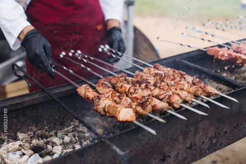 Food festival with food stall kiosk, open-air outdoor fair market, assortment of different traditional European grilled barbecued street food with sausages, bbq, chicken, pork and lamb on a large pan