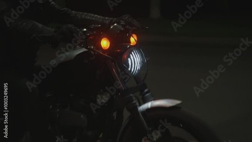 Biker wearing black helmet and black leather jacket rushes along night road. Close-up. Handheld pov shot of camera. Main advantage of traveling by motorcycle is ease and feeling of freedom
