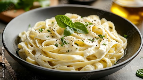 A bowl of fettuccine pasta with a creamy white sauce.