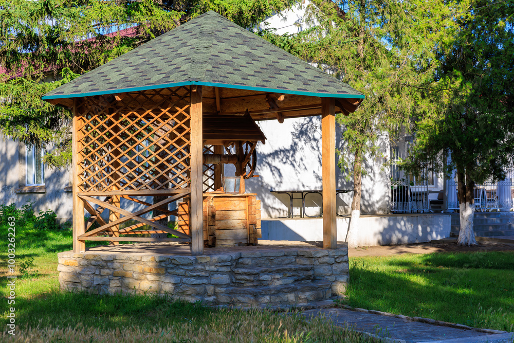 Naklejka premium A wooden pavilion with a fountain in the middle