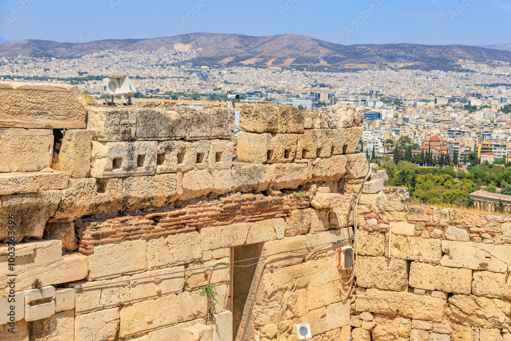 Fototapeta premium A stone wall with a window and a camera on top of it, Acropolis in Athens