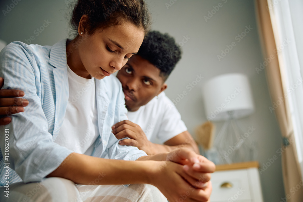 Caring African American man comforting his girlfriend while she's feeling sad. Caring African American man comforting his girlfriend while she's feeling sad.