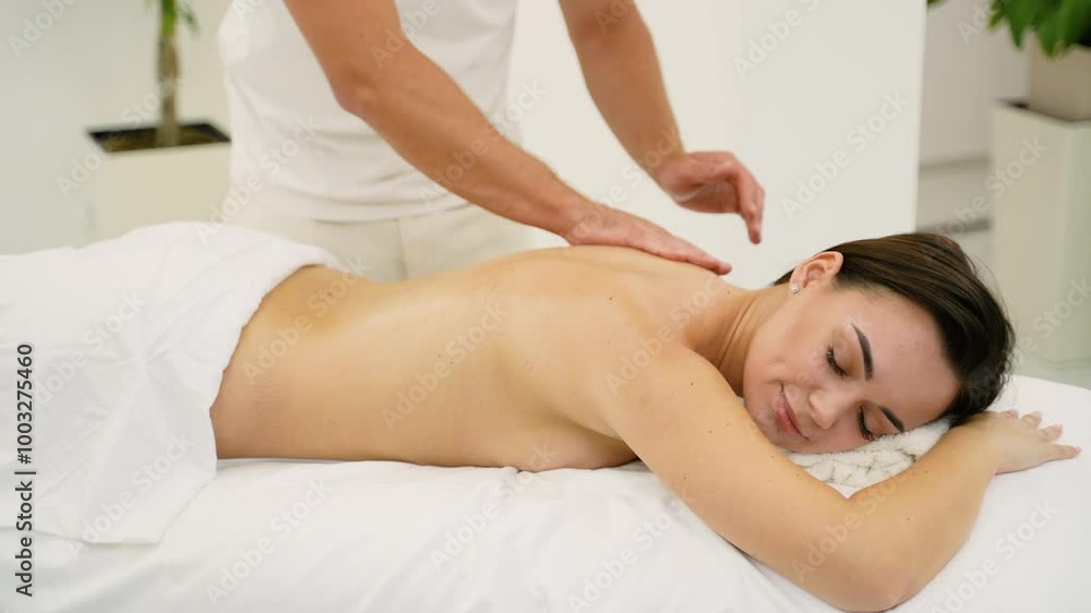 Woman Relaxing During a Soothing Back Massage in a Spa Woman Relaxing During a Soothing Back Massage in a Spa
