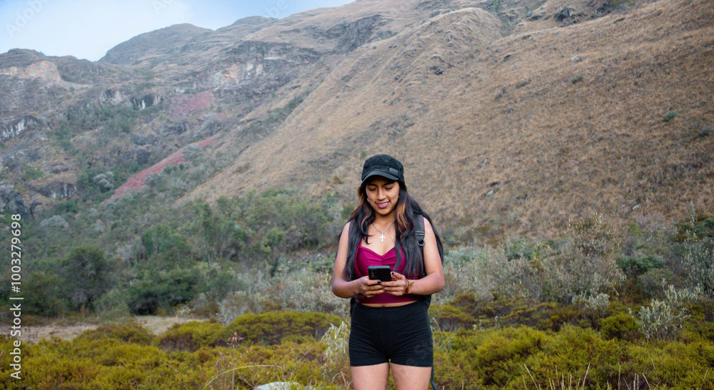 Naklejka premium Atractiva joven turista con short responde a videollamadas al aire libre, chica inteligente se comunica con entusiasmo en conferencia en línea al aire libre, turista hablando de grabar contenido
