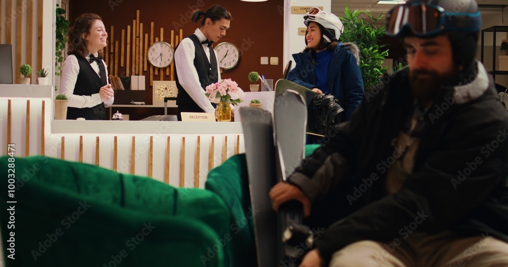 Personnel guiding asian guest and aiding in going skiing on alpine ski slopes. The hotel concierge gives advice to woman regarding mountain resort intense wintertime activity. Personnel guiding asian guest and aiding in going skiing on alpine ski slopes. The hotel concierge gives advice to woman regarding mountain resort intense wintertime activity.