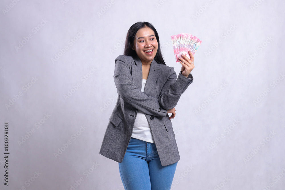 expression of beautiful mature office woman happy candid holding rupiah money in arms wearing gray suit isolated on white background. for giveaway content, lifestyle, prize, event, competition expression of beautiful mature office woman happy candid holding rupiah money in arms wearing gray suit isolated on white background. for giveaway content, lifestyle, prize, event, competition