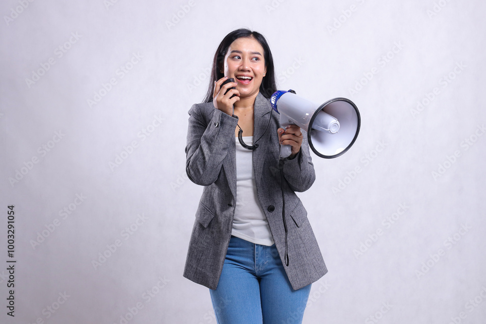 beautiful young lady shouting formal happy candid hand holding loudspeaker megaphone and microphone wearing grey suit isolated on white background. fashion, lifestyle, beauty, sale, company concept beautiful young lady shouting formal happy candid hand holding loudspeaker megaphone and microphone wearing grey suit isolated on white background. fashion, lifestyle, beauty, sale, company concept