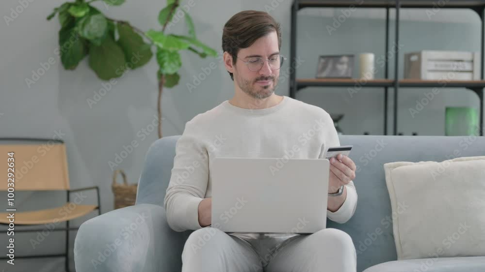 Online Banking by Young Man while Sitting on Sofa at Home Online Banking by Young Man while Sitting on Sofa at Home