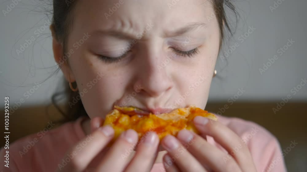 Child eating slice of homemade pizza indoor. A view of little girl with a slice of pizza eating in the kitchen. Child eating slice of homemade pizza indoor. A view of little girl with a slice of pizza eating in the kitchen.