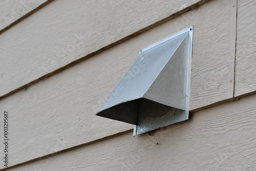 Dryer vent poking through vinyl siding.