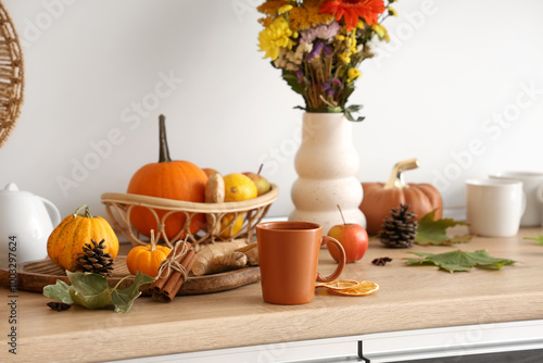 Wallpaper Mural Cup of hot green tea, pumpkins, dried orange slices and wooden tray on table in kitchen Torontodigital.ca