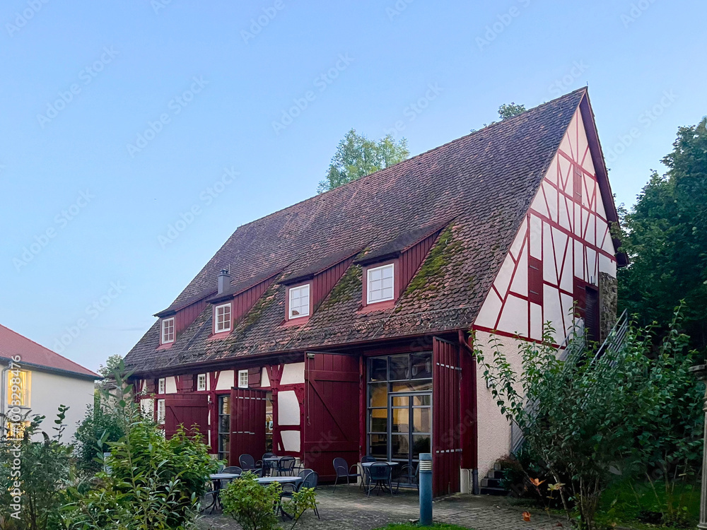 Fototapeta premium Charming traditional German style house with red roof and green plants