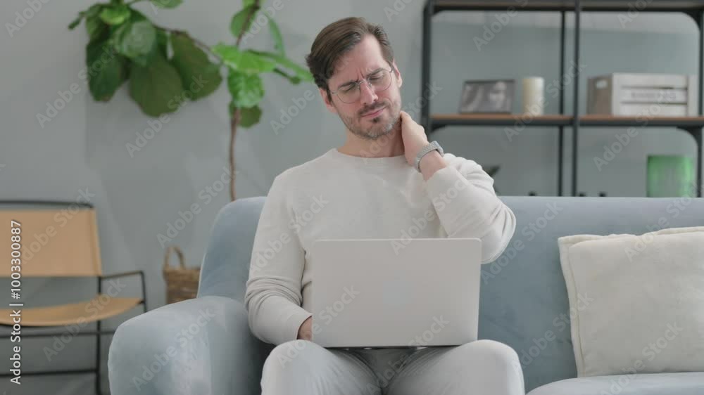 Young Man with Neck Pain Using Laptop at Home Young Man with Neck Pain Using Laptop at Home