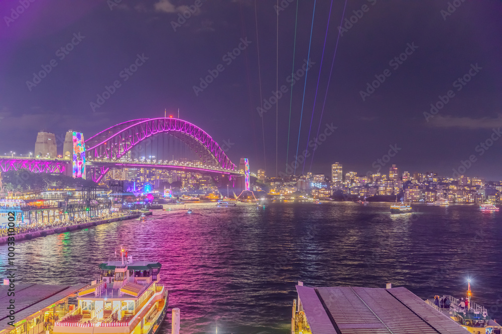 Obraz premium Colourful Light show at night on Sydney Harbour NSW Australia. The bridge illuminated with lasers and neon coloured lights for the Sydney Vivid light show