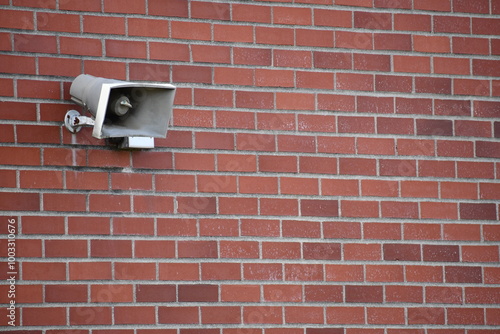 Red brick wall with PA speaker mounted.