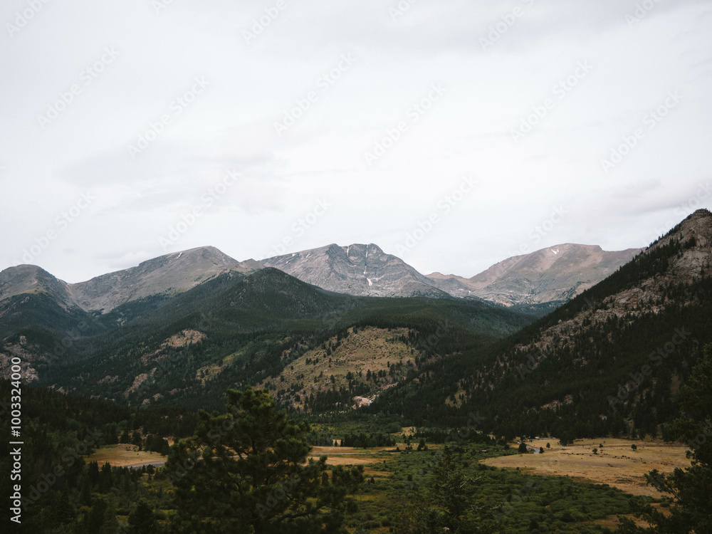 Expansive View of Rocky Mountain Valley with Serene Rolling Hills and Pine Forest on a Cloudy Day in Colorado Expansive View of Rocky Mountain Valley with Serene Rolling Hills and Pine Forest on a Cloudy Day in Colorado