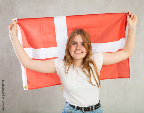 Pretty young female sudent holding the Danish flag in her hands photo