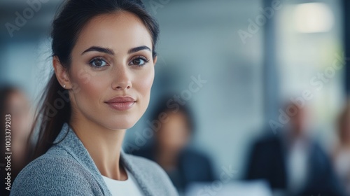 A woman in a professional setting, looking thoughtfully at the camera.