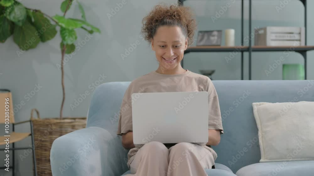 Hispanic Woman Celebrating while Reading Documents on Sofa Hispanic Woman Celebrating while Reading Documents on Sofa