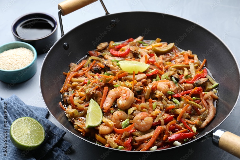 Stir-fry sea food in wok served on grey table Stir-fry sea food in wok served on grey table