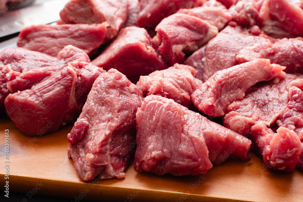 Close-up of Pork Shoulder Chunks On a Wooden Cutting Board: Pieces of Boston butt with a boning knife and a santoku knife on a wood chopping board Close-up of Pork Shoulder Chunks On a Wooden Cutting Board: Pieces of Boston butt with a boning knife and a santoku knife on a wood chopping board